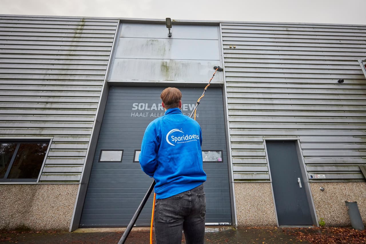 Gevel die voor de helft gereinigd is, met een duidelijk zichtbaar kleurverschil