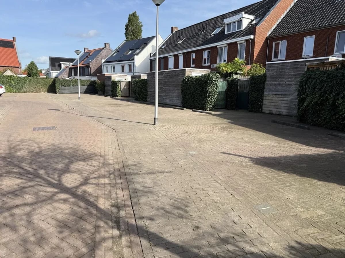 Onkruidvrij parkeerterrein bij een woonblok na onderhoud