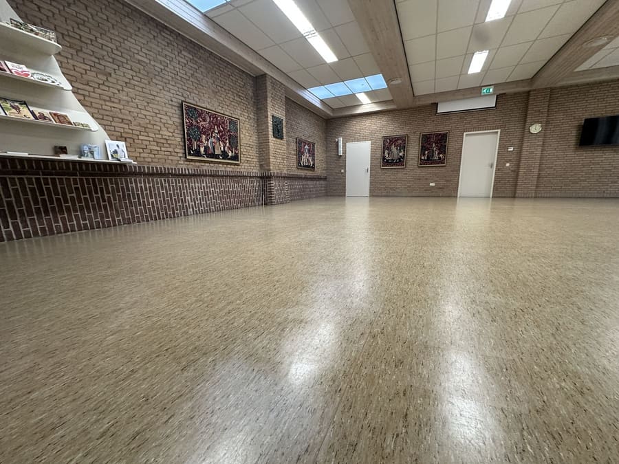 Dezelfde vloer met een glanzende polymeren coating na de behandeling