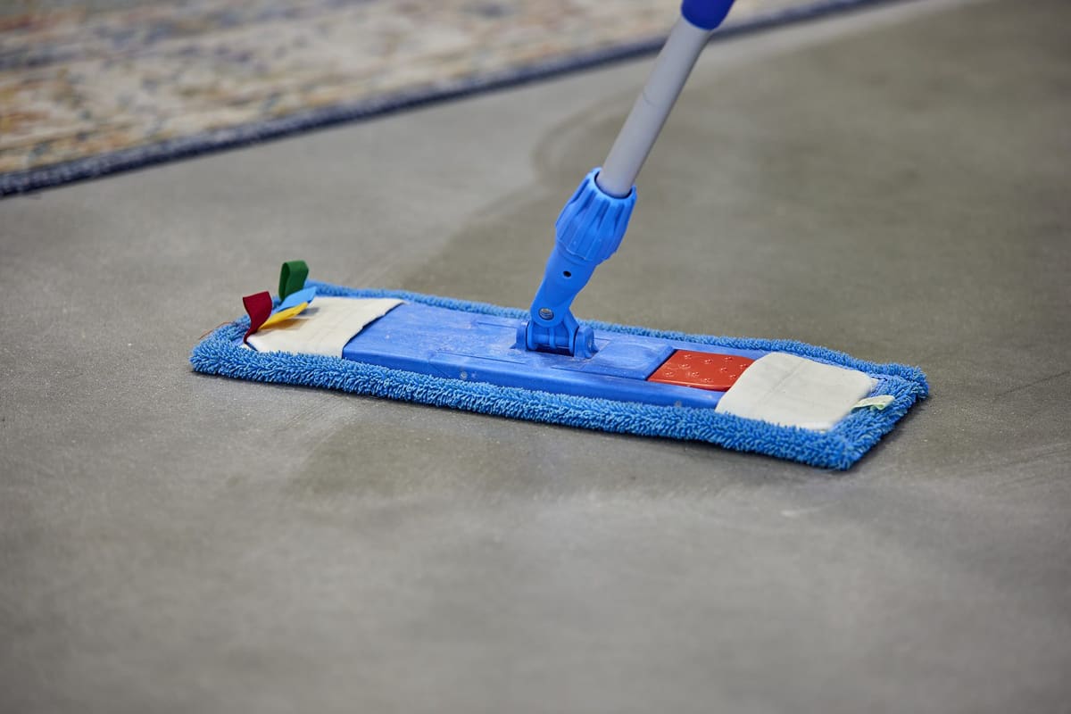 Close-up van een vlakmop tijdens het onderhoud van een gepolijste betonvloer