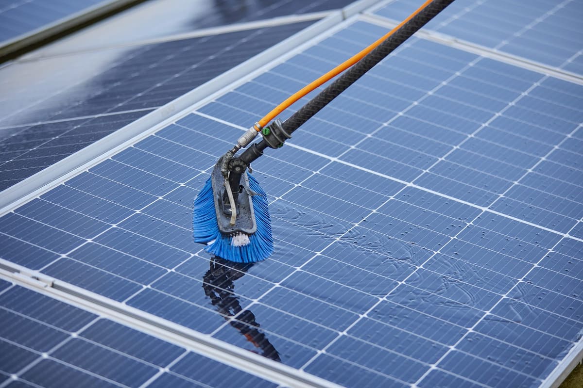 Close-up van de reinigingsborstel op een zonnepaneel tijdens het reinigen met osmosewater